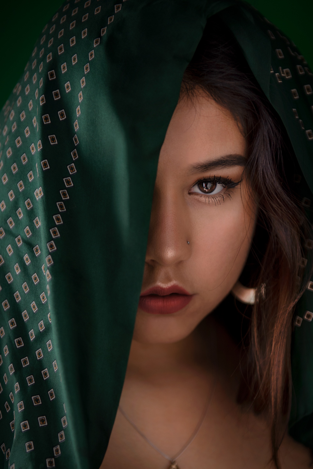 Enigmatic image of a woman with a scarf, revealing only half of her face, adding an element of curiosity.