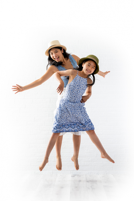 Two joyful Asian girls leaping with exuberance and delight.