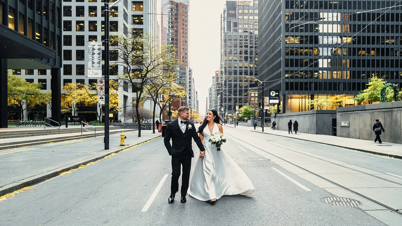 Downtown Toronto Wedding: Joyful bride and groom walking in the middle of the street.